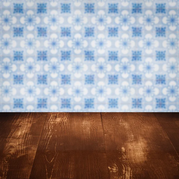 Wood table top and blur vintage ceramic tile pattern wall — Stock Photo, Image