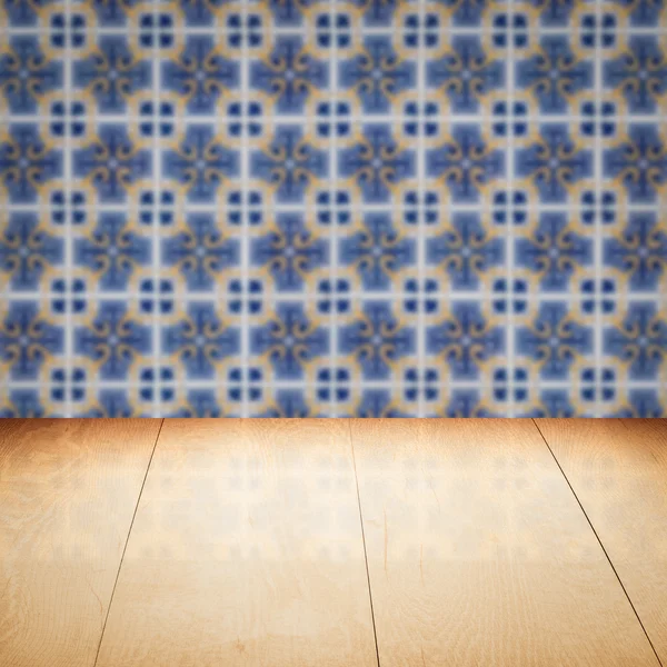 Wood table top and blur vintage ceramic tile pattern wall — Stock Photo, Image