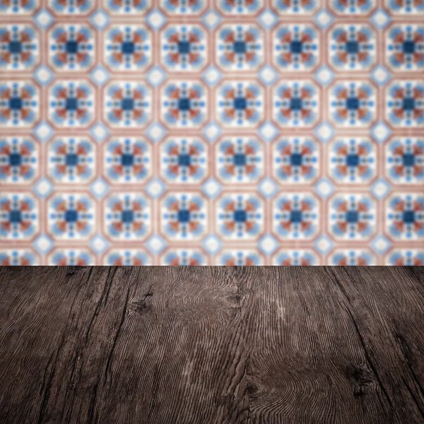 Wood table top and blur vintage ceramic tile pattern wall — Stock Photo, Image