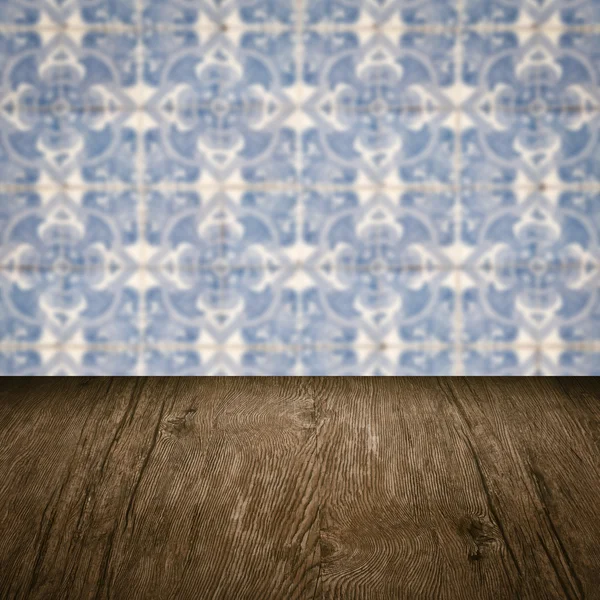 Wood table top and blur vintage ceramic tile pattern wall — Stock Photo, Image