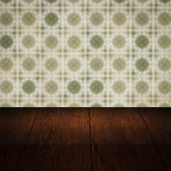 Wood table top and blur vintage ceramic tile pattern wall — Stock Photo, Image