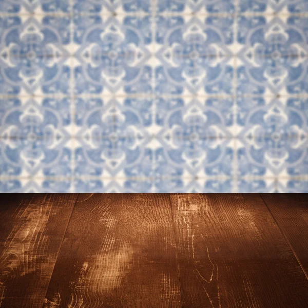 Wood table top and blur vintage ceramic tile pattern wall — Stock Photo, Image