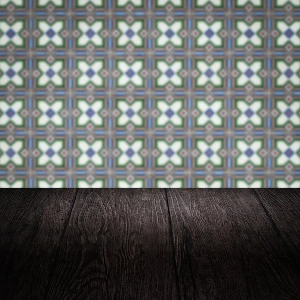 Wood table top and blur vintage ceramic tile pattern wall — Stock Photo, Image