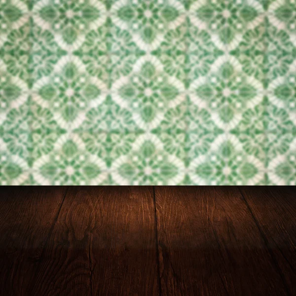 Wood table top and blur vintage ceramic tile pattern wall — Stock Photo, Image