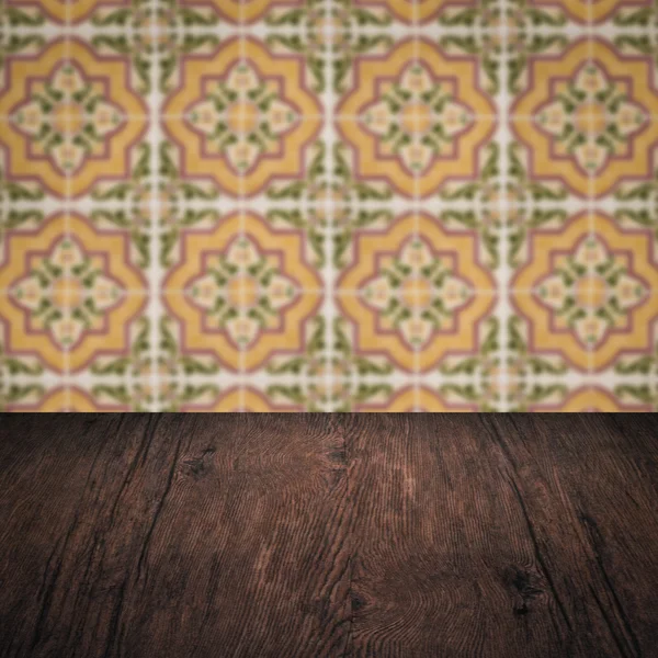 Wood table top and blur vintage ceramic tile pattern wall — Stock Photo, Image