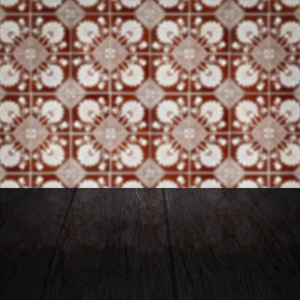 Wood table top and blur vintage ceramic tile pattern wall Royalty Free Stock Images