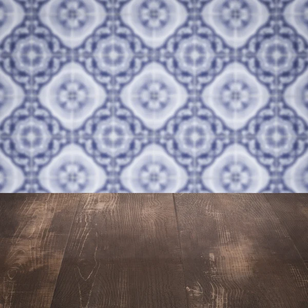 Wood table top and blur vintage ceramic tile pattern wall — Stock Photo, Image