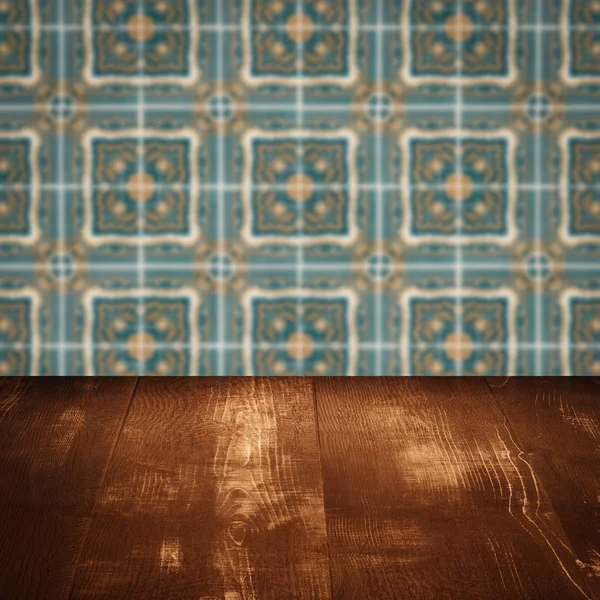 Wood table top and blur vintage ceramic tile pattern wall — Stock Photo, Image