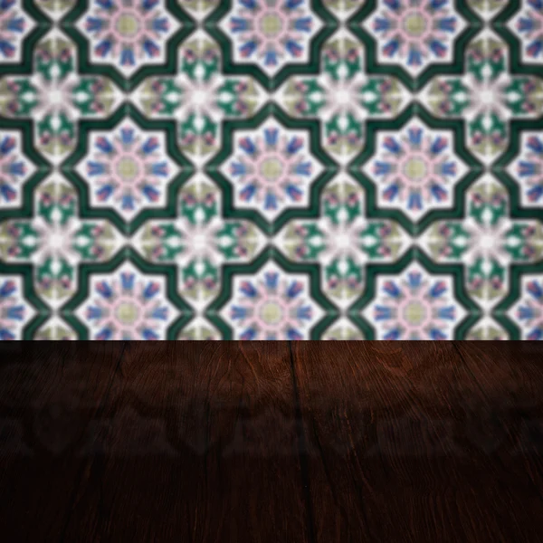 Wood table top and blur vintage ceramic tile pattern wall — Stock Photo, Image