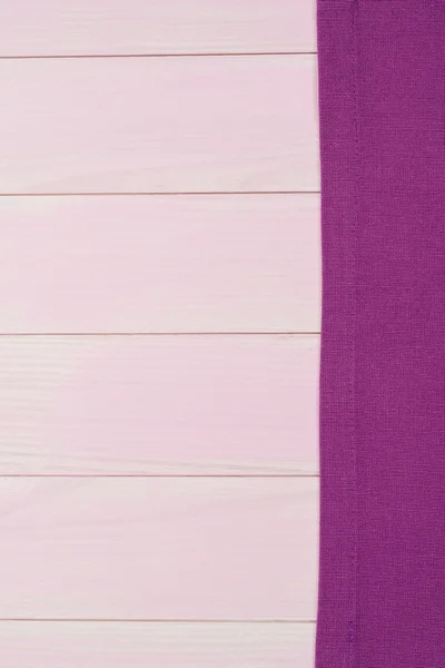 Paarse handdoek over houten tafel — Stockfoto