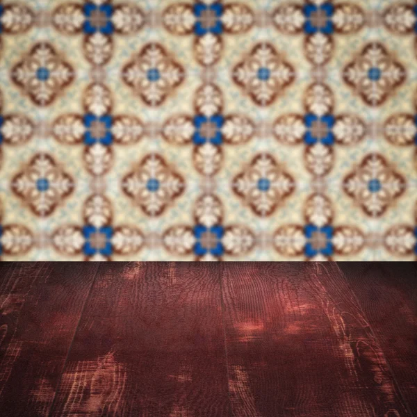 Wood table top and blur vintage ceramic tile pattern wall — Stock Photo, Image