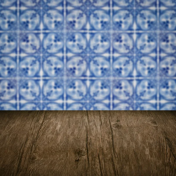 Wood table top and blur vintage ceramic tile pattern wall — Stock Photo, Image