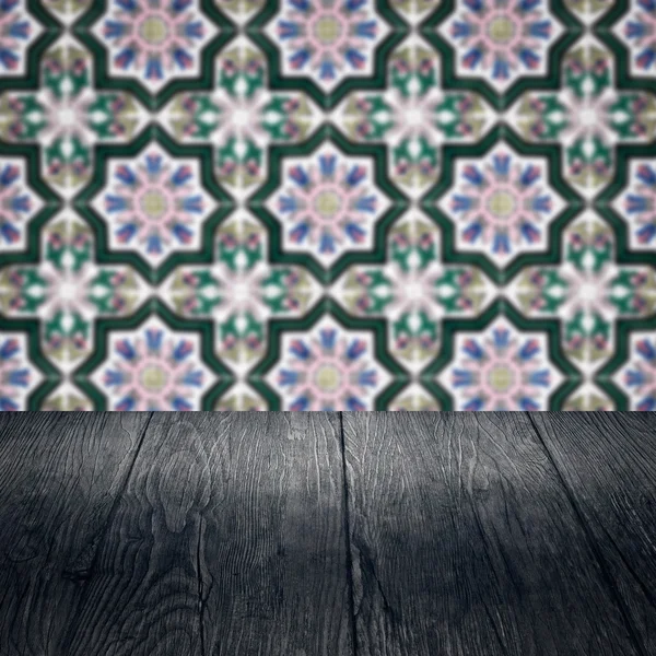 Wood table top and blur vintage ceramic tile pattern wall — Stock Photo, Image