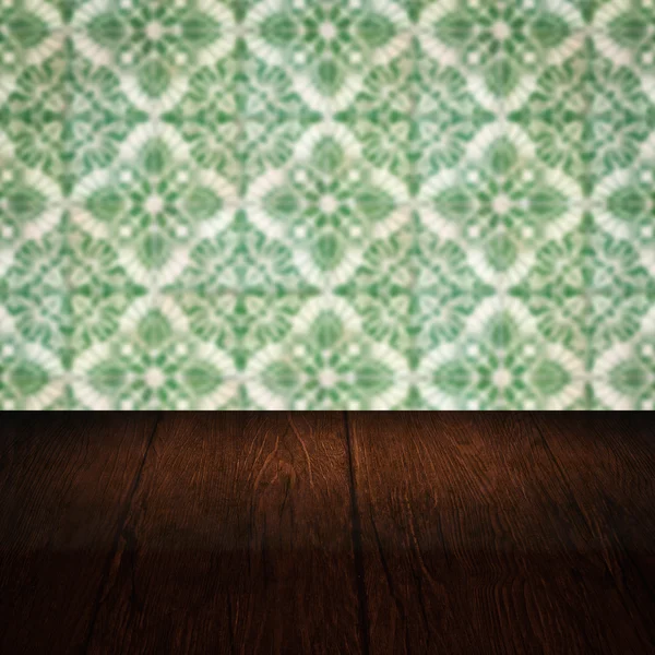 Wood table top and blur vintage ceramic tile pattern wall — Stock Photo, Image