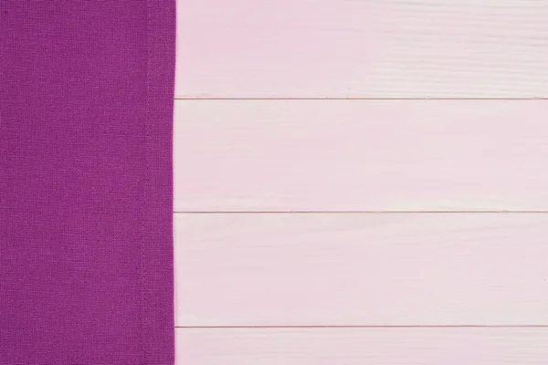Na drewnianym stole fioletowy ręcznik — Zdjęcie stockowe