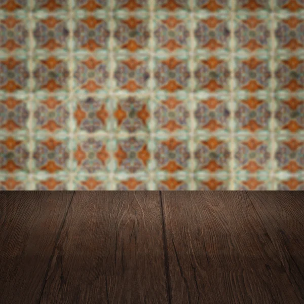 Wood table top and blur vintage ceramic tile pattern wall — Stock Photo, Image