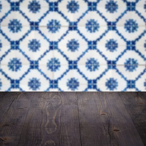 Wood table top and blur vintage ceramic tile pattern wall — Stock Photo, Image