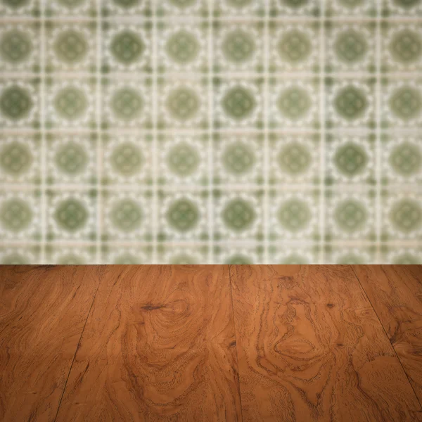 Wood table top and blur vintage ceramic tile pattern wall — Stock Photo, Image