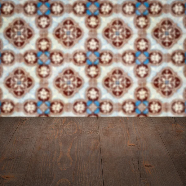 Wood table top and blur vintage ceramic tile pattern wall — Stock Photo, Image