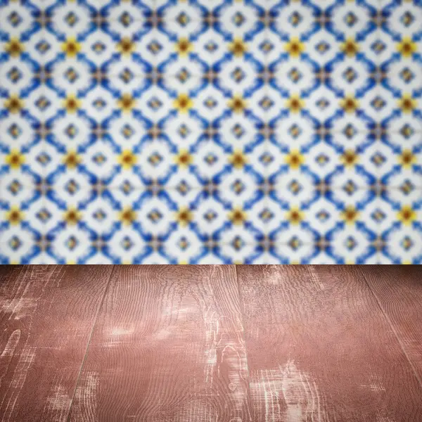 Wood table top and blur vintage ceramic tile pattern wall — Stock Photo, Image