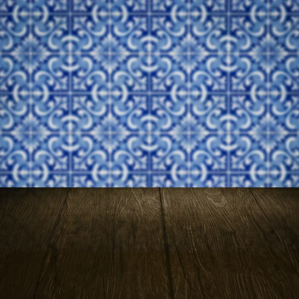 Wood table top and blur vintage ceramic tile pattern wall — Stock Photo, Image