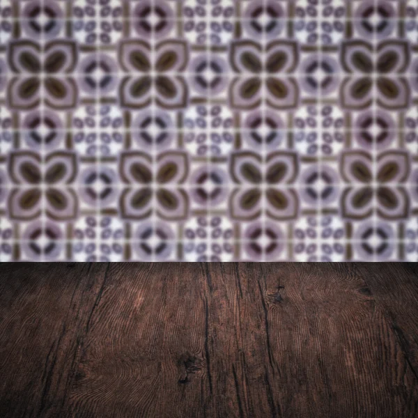 Wood table top and blur vintage ceramic tile pattern wall — Stock Photo, Image