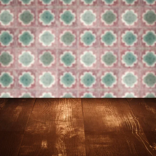 Wood table top and blur vintage ceramic tile pattern wall — Stock Photo, Image