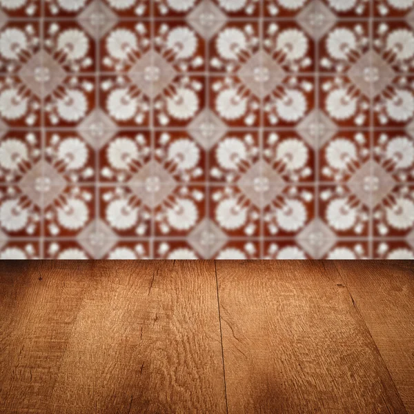 Wood table top and blur vintage ceramic tile pattern wall — Stock Photo, Image