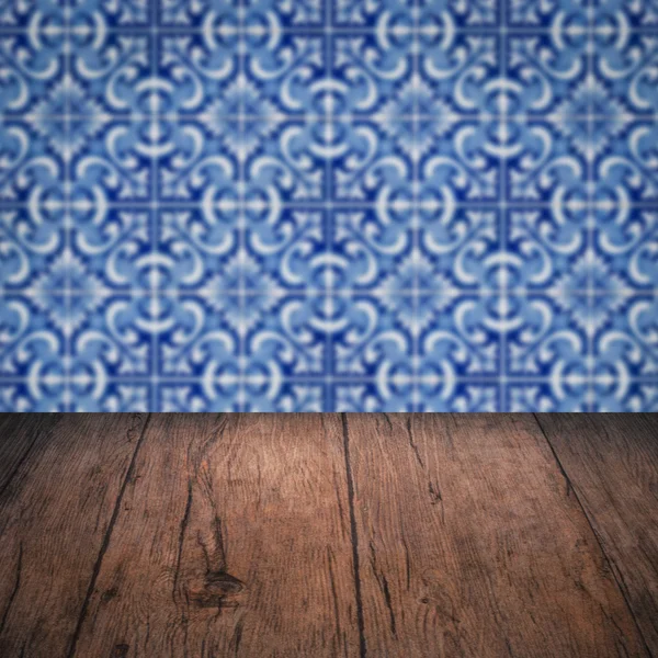 Wood table top and blur vintage ceramic tile pattern wall — Stock Photo, Image