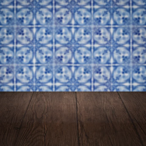 Wood table top and blur vintage ceramic tile pattern wall — Stock Photo, Image