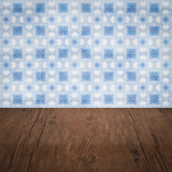 Wood table top and blur vintage ceramic tile pattern wall — Stock Photo, Image