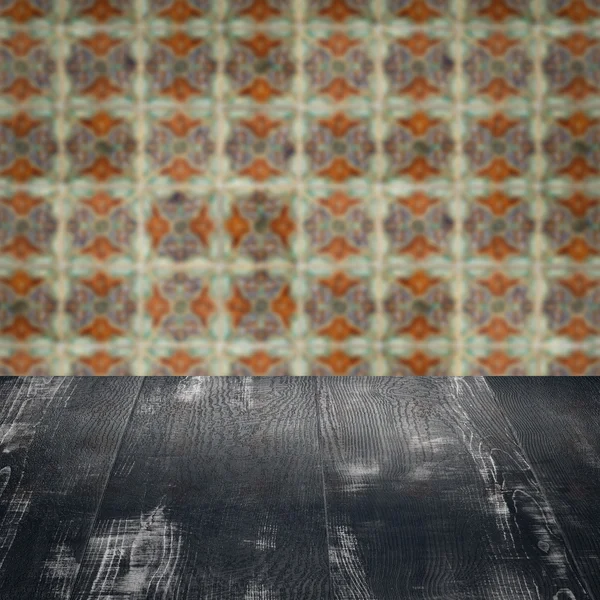 Wood table top and blur vintage ceramic tile pattern wall — Stock Photo, Image