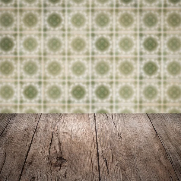 Wood table top and blur vintage ceramic tile pattern wall — Stock Photo, Image