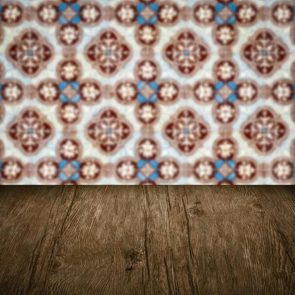 Wood table top and blur vintage ceramic tile pattern wall — Stock Photo, Image