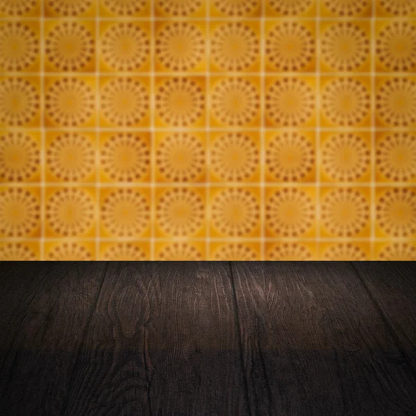 Wood table top and blur vintage ceramic tile pattern wall — Stock Photo, Image