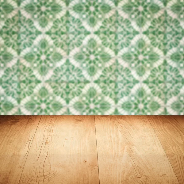 Wood table top and blur vintage ceramic tile pattern wall — Stock Photo, Image