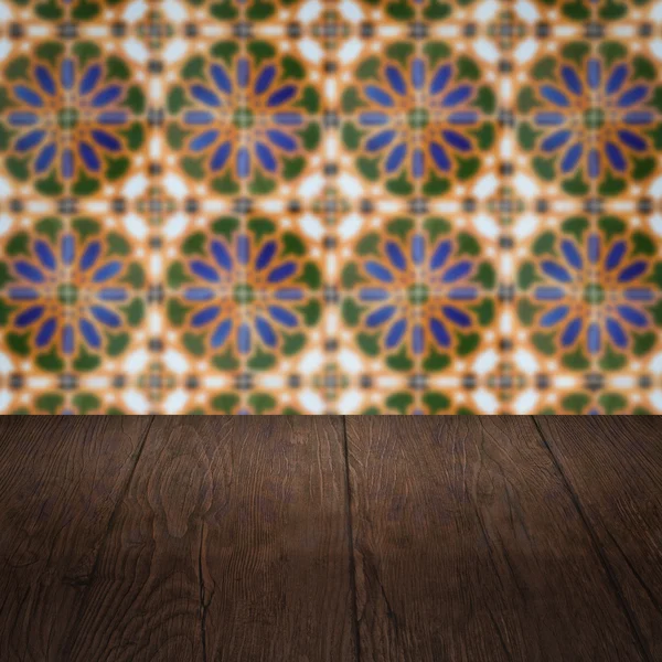 Wood table top and blur vintage ceramic tile pattern wall — Stock Photo, Image