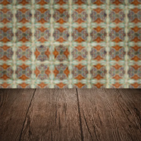 Wood table top and blur vintage ceramic tile pattern wall — Stock Photo, Image