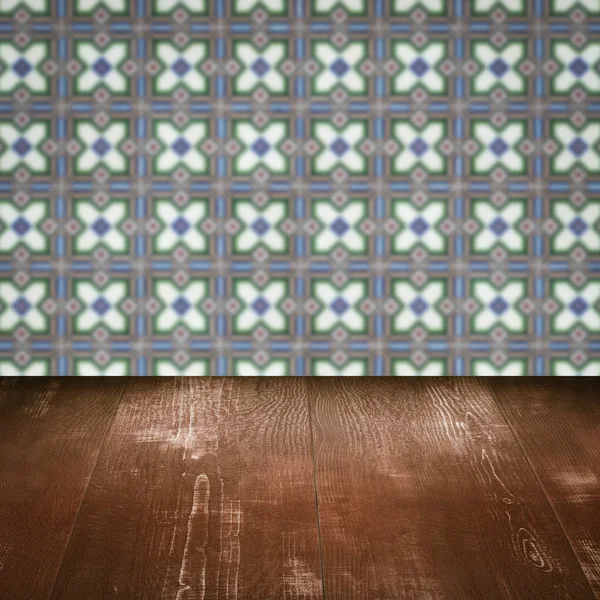 Wood table top and blur vintage ceramic tile pattern wall — Stock Photo, Image