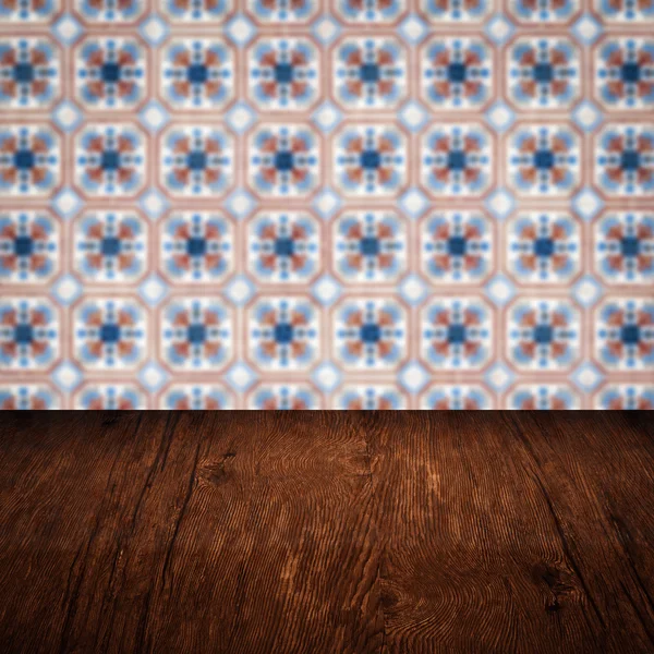 Wood table top and blur vintage ceramic tile pattern wall — Stock Photo, Image