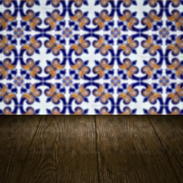 Wood table top and blur vintage ceramic tile pattern wall — Stock Photo, Image