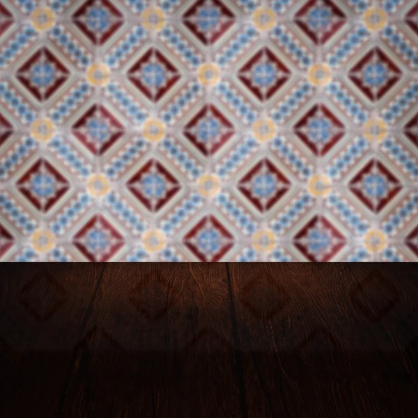 Wood table top and blur vintage ceramic tile pattern wall — Stock Photo, Image