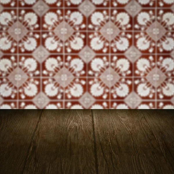 Wood table top and blur vintage ceramic tile pattern wall — Stock Photo, Image