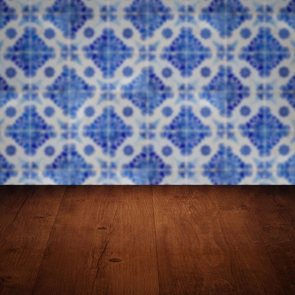 Wood table top and blur vintage ceramic tile pattern wall — Stock Photo, Image