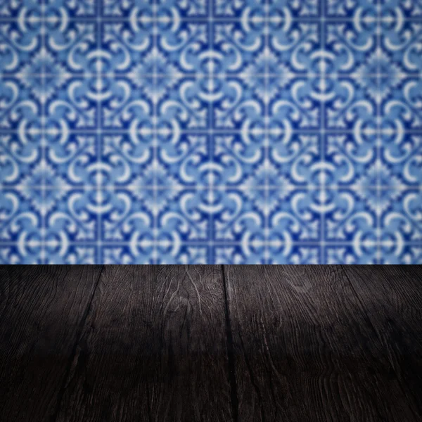 Wood table top and blur vintage ceramic tile pattern wall — Stock Photo, Image