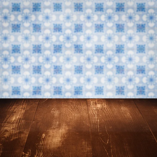 Wood table top and blur vintage ceramic tile pattern wall — Stock Photo, Image