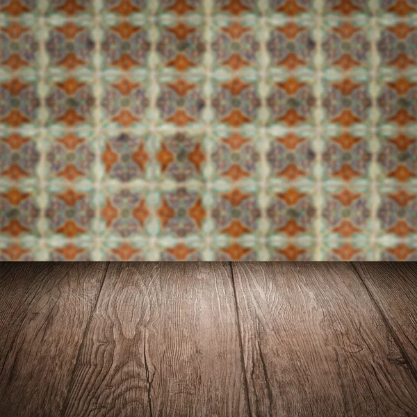 Wood table top and blur vintage ceramic tile pattern wall — Stock Photo, Image