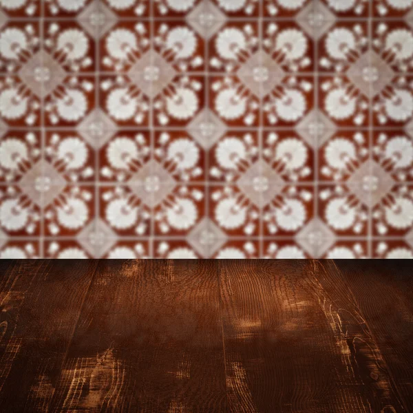 Wood table top and blur vintage ceramic tile pattern wall — Stock Photo, Image