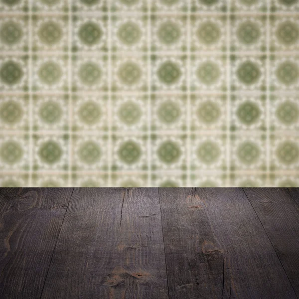 Wood table top and blur vintage ceramic tile pattern wall — Stock Photo, Image