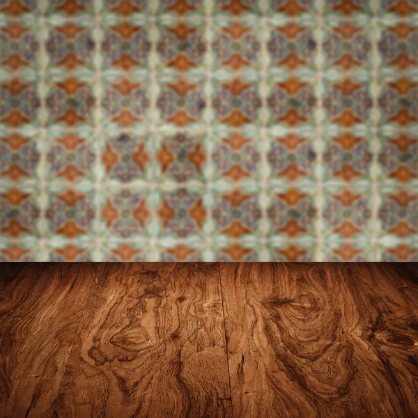 Wood table top and blur vintage ceramic tile pattern wall — Stock Photo, Image